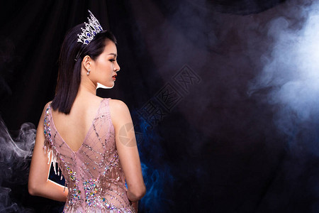 选美小姐选美大赛的肖像在粉红色亮片晚礼服与钻石皇冠图片