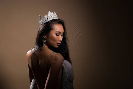 选美小姐选美大赛肖像在露背晚装皮草礼服与闪发光的钻石皇冠背景图片