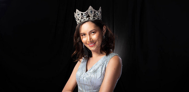 选美小姐选美大赛的肖像在亮片晚礼服长裙与闪发光的钻石皇冠图片