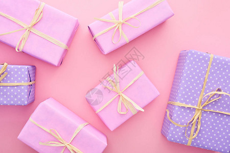 彩色礼品盒的顶部视图蝴蝶结以粉色隔开背景图片