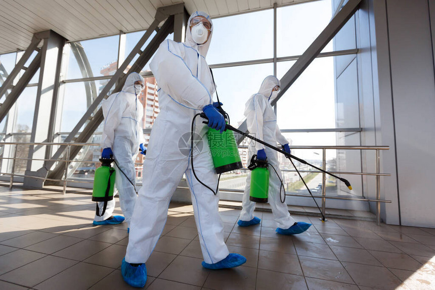 冠状生物危害的保护戴呼吸器和防护服的男子用化学品清洁公共场图片