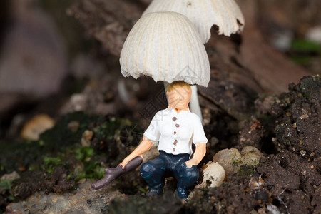 休息在蘑菇下的微型人图片