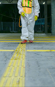 穿着防护服的人用化学品对公共交通站进行消毒图片