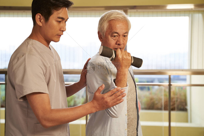 在康复中心物理治疗师指导下使用哑铃锻图片