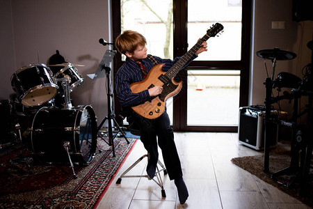 小男孩在家弹吉他待在家里图片