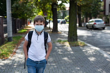 戴面具的男孩以医疗面罩上学校和图片
