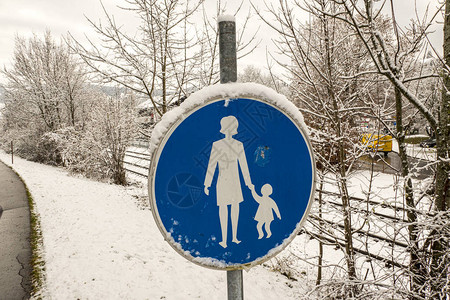 城市雪中蓝色的行人标志图片