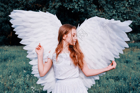 长着天使翅膀和白裙子的可爱caucasia女孩假扮图片
