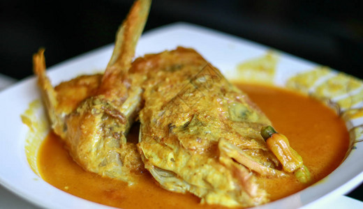 黑色背景上的鲷鱼头gulai咖喱古来是一种含有丰富辛辣和多汁图片