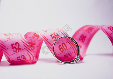 粉红色的摄像带和贴近它的结婚戒指图片