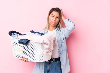 年轻caucasian女人拿起一件脏衣服图片