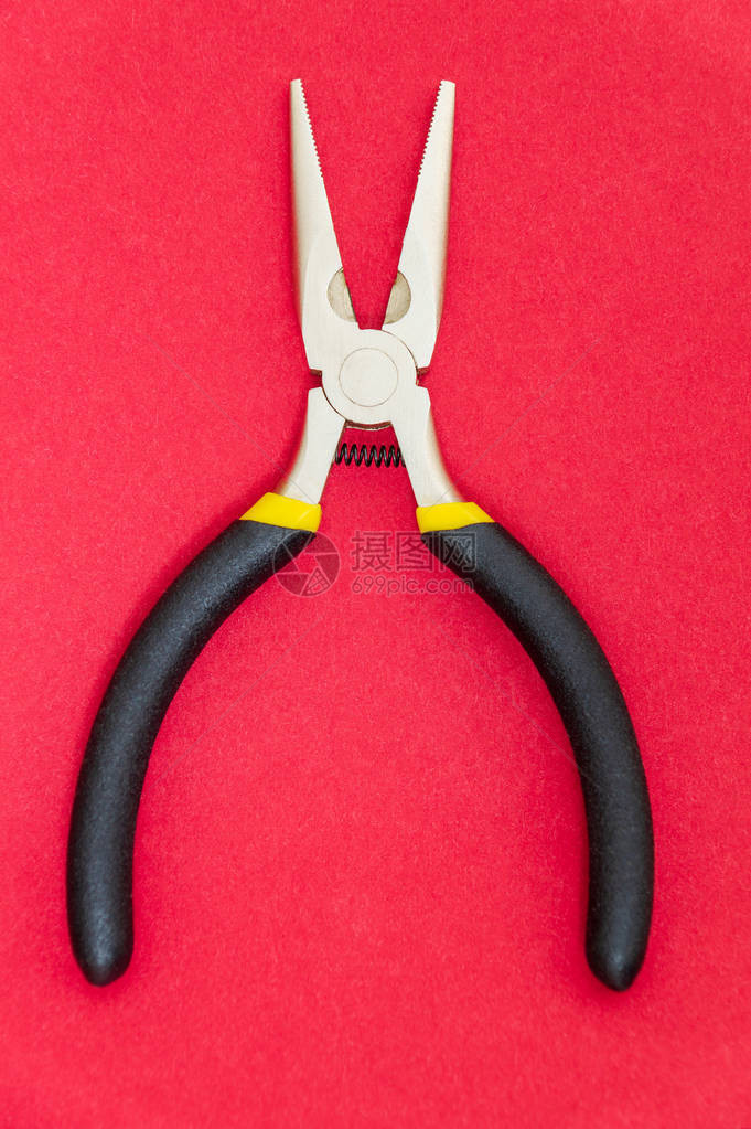红色背景电工大师用带黑色橡胶手柄的单钳子工具图片