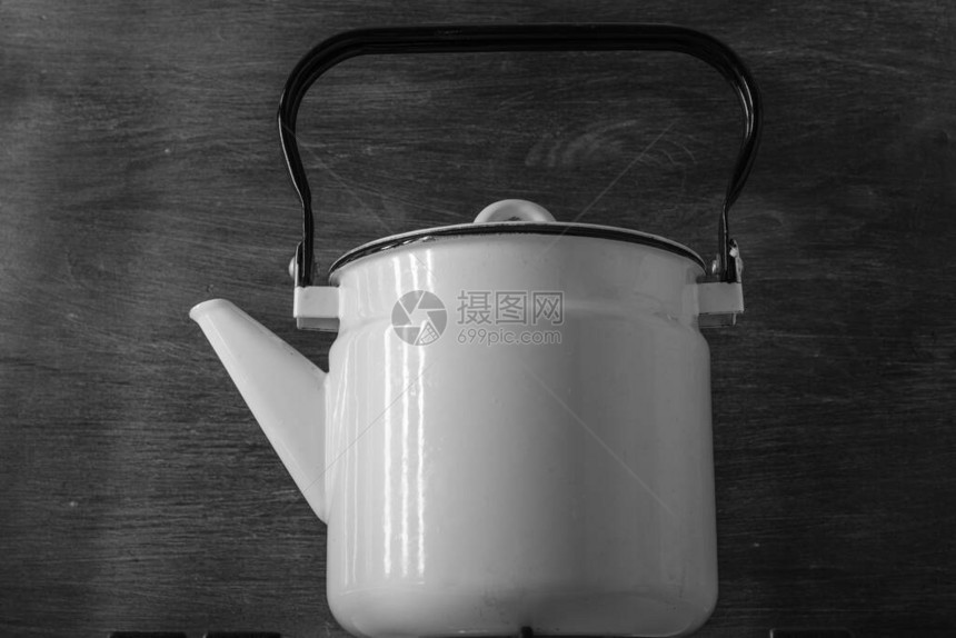 白色珐琅复古茶壶站在炉子上图片