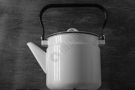 白色珐琅复古茶壶站在炉子上图片