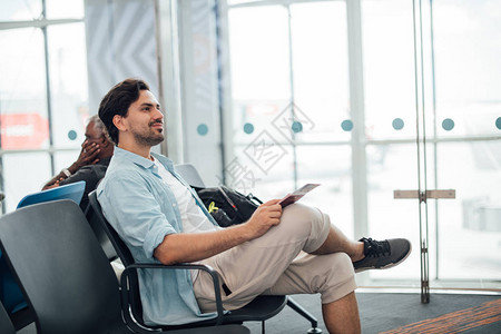 背着包的人坐在机场在候机楼等待登图片