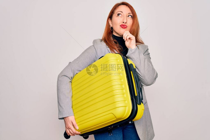 年轻漂亮的红发美女拿着行李箱准备去商业旅行的姑娘面对严肃地思考问题图片