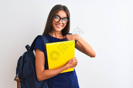 戴着背包眼镜的年轻女学生拿着书在孤立的白色背景上图片