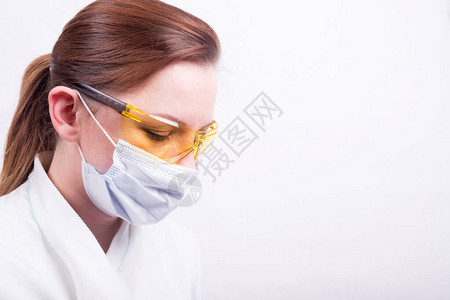 穿戴医疗面具和黄色保护眼镜的女医生的肖像图片