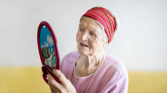 高加索老妇人在镜子里看着自己图片