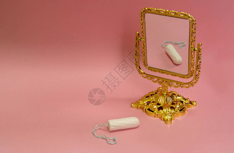 白色卫生棉条和粉红色背景的镜子图片