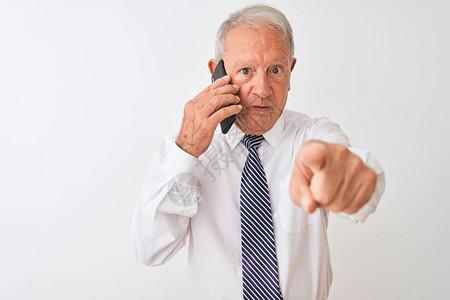 白发苍的高级商人在孤立的白色背景上用智能手机说话图片