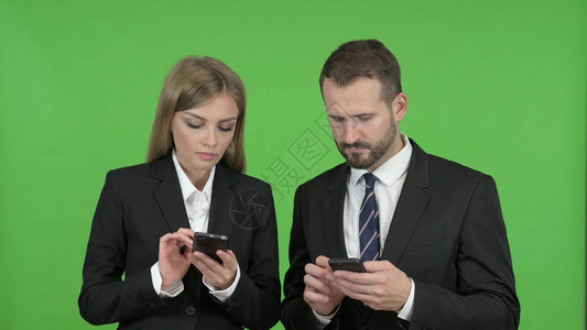 使用智能电话对抗色调键的男女商业专人员图片