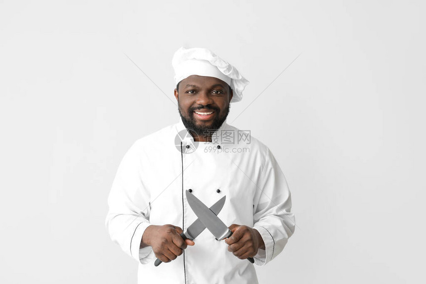 白色背景上拿着刀的非洲裔美国男厨师图片