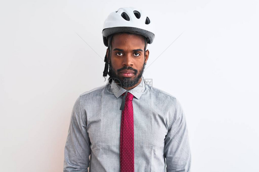 身着自行车头盔的非洲美籍商人在孤立的白色背景和面部严重表情上露出严肃的面孔简单而自图片