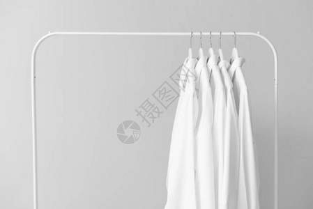浅色背景下干洗后的衣服架背景图片