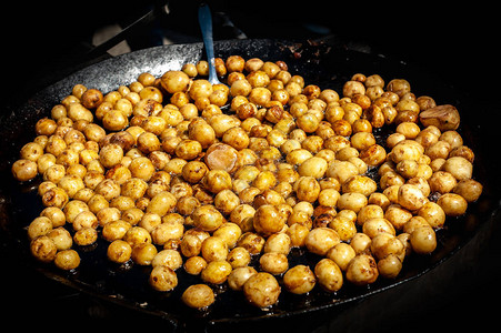 许多黄色小固体非切片土豆从油上涂光图片