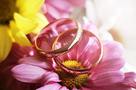 鲜花上的结婚戒指特写镜头如此接近图片