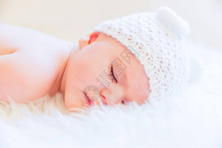 戴着熊耳朵帽子睡得安稳的可爱女婴图片