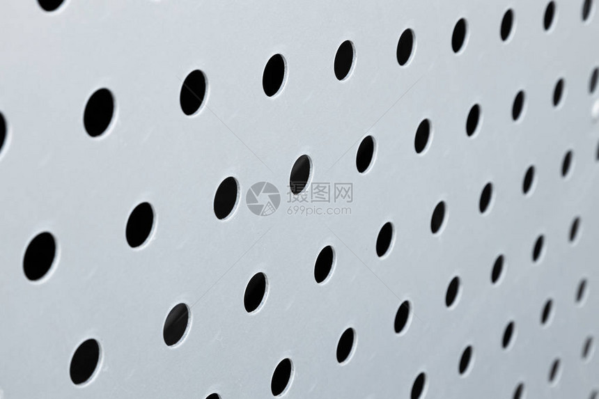 白色背景穿孔金属面板表面圆洞纹理上的黑色大图片