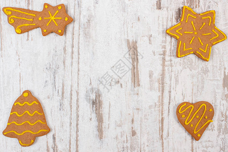 新鲜出炉的自制装饰姜饼旧白色木质背景上的圣诞饼干和文本复制图片