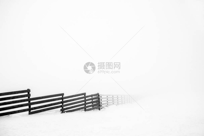 雪中的木栅栏晨雾图片