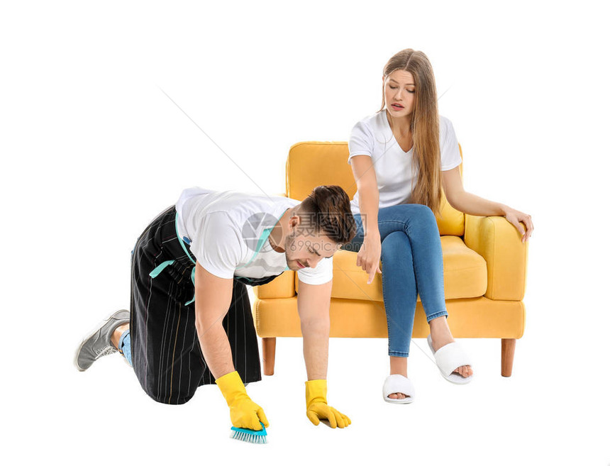 年轻丈夫做家务而其懒妻子却在白色背景图片