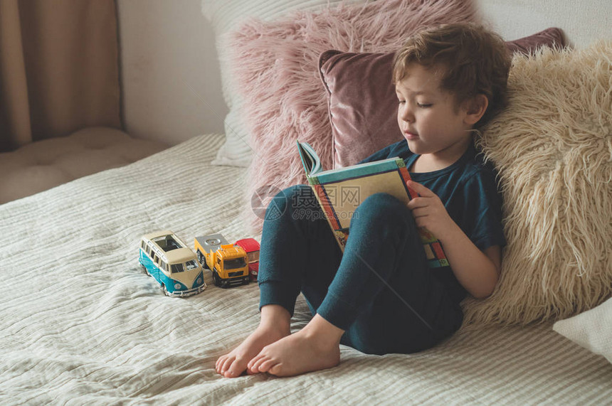 儿童阅读书孩子们看书一个小男孩坐在床上图片
