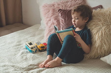 儿童阅读书孩子们看书一个小男孩坐在床上图片