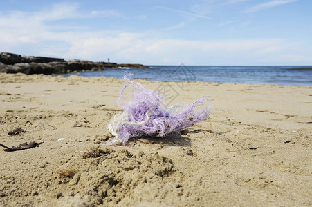 在沙滩上钓鱼尼龙网沙滩上的垃圾肮脏的海岸环境污染拯救地球生态问图片