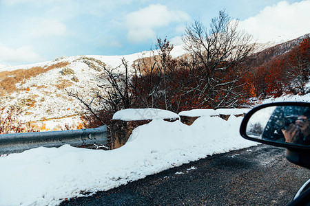 男人从车内到雪山拍照片反射在汽车图片