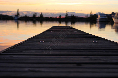 日落时伸入Vesijrvi湖的Wooden码图片