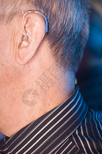 白种老人穿着现代数字助听器背景图片