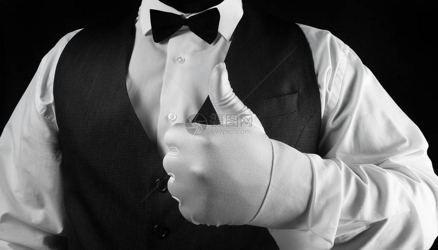照片中一位白衬衫和黑腰衣服务员在黑色背心上看到白色手套上的拇指图片