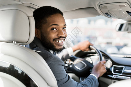 非洲裔美国商人在新汽车户外驾车门中驾驶着微笑到相机的镜头座位图片