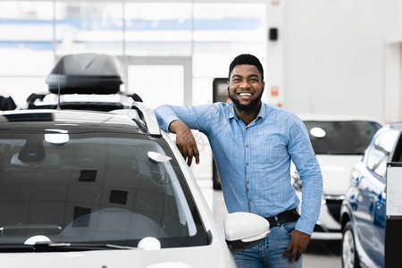 购买汽车者欢乐的非洲男子在新自动经销商店附近活动图片