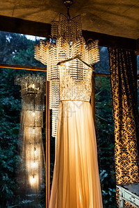 优雅的婚礼服挂在室内穿着令人惊叹的老旧吊灯美背景图片