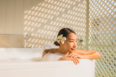 年轻的肖像女亚洲女人放松在浴缸里洗澡图片