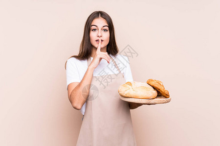 年轻的caucasian面包师女人孤立地保守秘图片