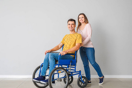 坐在轮椅上的残疾青年男子及其妻图片