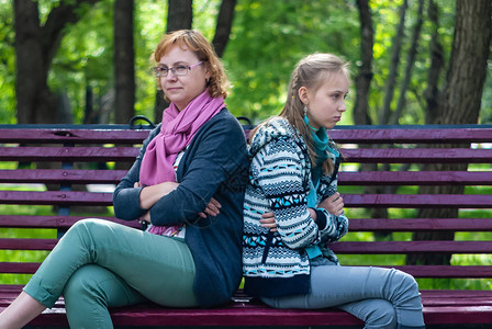 母亲和十几岁的女儿正坐在公园的长椅上图片